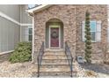 Close-up of the front entrance, showcasing the stone archway, dark red door with wreath, and inviting steps at 6509 Sunset Manor Dr, Wake Forest, NC 27587