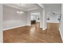 Spacious living room with gleaming hardwood floors, neutral walls, and an open layout to the dining area at 6509 Sunset Manor Dr, Wake Forest, NC 27587