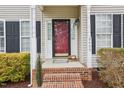 Welcoming front porch with red door, brick steps, and address number, creating a warm entry to the home at 8409 Astwell Ct, Raleigh, NC 27615