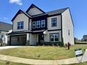 A beautiful two-story home with a 2-car garage, black trim, stone accents, and a well-manicured lawn at 100 N Stonemill Trl # Homesite 252, Wilson's Mills, NC 27520