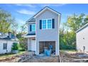 New two-story home featuring gray siding, black shutters, and an attached garage at 102 Woodson St, Oxford, NC 27565