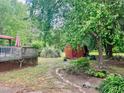 A backyard features a wooden deck, storage shed, stone pathway, greenery and a turtle garden ornament at 1413 Bud Hawkins Rd, Dunn, NC 28334