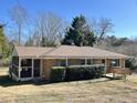 View of brick home exterior with screened-in porch and manicured bushes at 1516 Park Ln, Hillsborough, NC 27278