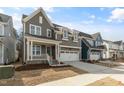 A gray two-story home features a covered porch and a two-car garage in a residential area at 1721 Birdhaven Ln, Wendell, NC 27591