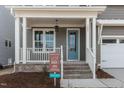 Inviting front porch with white railings, brick steps, and an attractive blue front door at 1721 Birdhaven Ln, Wendell, NC 27591