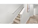 Carpeted staircase with white handrail complements the neutral walls and flooring at 1909 Frost Dr, Haw River, NC 27258