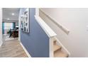 Bright hallway with neutral tones and a modern art piece leading to a dining area with natural light at 1910 Frost Dr, Haw River, NC 27258