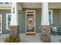 Charming front entrance with stone pillars and 'New Home' welcome mat at 26 Kitty Branch Way, Smithfield, NC 27577