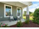 Inviting front porch with rocking chairs and stone pillar accents at 26 Kitty Branch Way, Smithfield, NC 27577