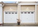 A close-up of two garage doors, each with windows at the top and decorative carriage lights at 2815 Mebane Ln, Durham, NC 27703