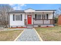 Charming single-story home featuring a welcoming porch and well-maintained front yard with a red front door at 318 Fulton St, Burlington, NC 27217