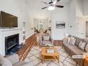 Bright living room featuring a fireplace, hardwood floors, ceiling fan, and an open layout to the dining area at 4205 Rockside Hills Dr, Raleigh, NC 27603