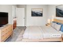 Bright main bedroom featuring a light wood frame bed, neutral walls, and hardwood floors in the hallway at 4205 Rockside Hills Dr, Raleigh, NC 27603