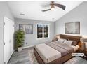 This bright main bedroom features a ceiling fan, a window with wooded view, and an ensuite bathroom at 4213 Sunscape Ln, Raleigh, NC 27613