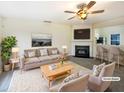 Bright living room with a fireplace, ceiling fan, and tastefully selected neutral furniture at 5107 Tomasita Ct, Raleigh, NC 27616