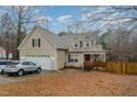 Charming two-story home with attached two car garage, front porch and mature trees at 589 Vinson Rd, Clayton, NC 27527