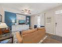 Cozy living room featuring blue accent wall, ceiling fan, and a comfortable sofa with natural light at 5908 Giddings St, Raleigh, NC 27616