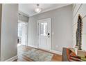 Bright entryway with hardwood floors, white trim, a patterned rug, and a door with glass panes at 67 Rice Road # 01, Zebulon, NC 27597