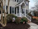 Welcoming front porch with white railings, brick steps, and well-manicured landscaping adds curb appeal at 704 Tranter Dr, Apex, NC 27502