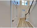 Bright foyer with soaring ceiling, light wood floors, staircase, and white paneled front door at 7727 Weathered Oak Way, Raleigh, NC 27616