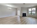 Spacious living room with light wood flooring, fireplace, and sliding glass door at 7727 Weathered Oak Way, Raleigh, NC 27616