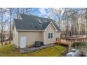 A rear exterior view of a home with a wooden deck, an outdoor dining table, and lots of trees at 151 Cheyenne Dr, Louisburg, NC 27549