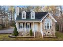 Charming home featuring stone accents, dormer windows, and a covered porch at 151 Cheyenne Dr, Louisburg, NC 27549