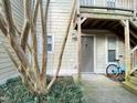 Exterior view of the entrance featuring a storm door, landscaping, and a bicycle at 1513 E Franklin St # C129, Chapel Hill, NC 27514