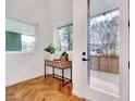 Inviting entryway featuring herringbone hardwood floors, a modern table, and a view to the outside at 1604 Malta Ave, Raleigh, NC 27610