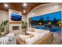Cozy covered patio features a fireplace, TV, and seamless access to a pool with a waterfall at 1804 Clifton Pines Dr, Cary, NC 27519