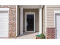 Close-up of the front door, complemented by stone accents and white trim at 1912 Frost Dr, Haw River, NC 27258