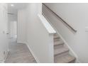 Bright staircase featuring carpeted steps, a white banister, and a sleek handrail at 1912 Frost Dr, Haw River, NC 27258