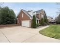 The exterior showcasing a brick home with a two car garage and well maintained lawn at 204 Brittany Pl, Cary, NC 27511