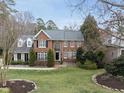 Classic brick facade with manicured lawn, white framed windows, black shutters, and mature landscaping at 204 Brittany Pl, Cary, NC 27511
