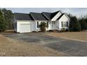 This single-story house features an attached garage and inviting front yard at 305 River Birch Run, Coats, NC 27521