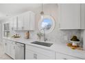 Bright kitchen featuring white cabinets, modern countertops, stainless steel appliances, and a unique round window at 4610 Lemon Heights Dr, Sanford, NC 27332