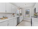 Modern kitchen featuring white cabinets, stainless steel appliances, quartz countertop and a window view at 4610 Lemon Heights Dr, Sanford, NC 27332