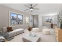 Cozy living room with neutral tones, modern furniture, a ceiling fan, and large windows for natural light at 4610 Lemon Heights Dr, Sanford, NC 27332