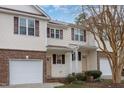 A pair of 2-story townhomes feature attached garages, brick facades, and light yellow vinyl siding at 4618 Pooh Corner Dr, Raleigh, NC 27616