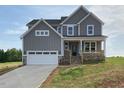 Beautiful new construction home featuring a stone-accented garage and inviting front porch at 4881 Grosbeak Ct, Mebane, NC 27302