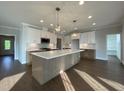 Spacious kitchen featuring a large island, stainless steel appliances, pendant lighting, and hardwood flooring at 4881 Grosbeak Ct, Mebane, NC 27302