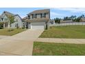 Charming two-story home with gray siding, black shutters, a two-car garage, and a well-manicured lawn at 50 Fontaine Dr, Franklinton, NC 27525