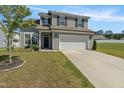 Charming two-story home with gray siding, black shutters, a two-car garage, and a well-manicured lawn at 50 Fontaine Dr, Franklinton, NC 27525