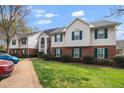 A row of townhouses with brick and siding, green shutters and well-maintained lawns create inviting curb appeal at 521 Renshaw Ct, Cary, NC 27518