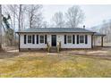 Charming ranch-style home featuring black shutters and neutral siding, complemented by a well-maintained front yard at 5635 Paragon Cir, Durham, NC 27712