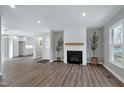 Spacious living room with a cozy fireplace, recessed lighting, and hardwood floors at 5635 Paragon Cir, Durham, NC 27712
