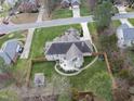 Backyard view of brick home showing deck, patio, fenced yard, and mature trees at 6 Kersey Ct, Durham, NC 27713