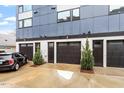 Three dark garage doors on a modern house with small trees planted in front, with a mini cooper parked on the driveway at 712 E Edenton St # 102, Raleigh, NC 27601