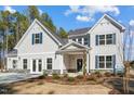 Beautiful home with light siding, stone accents, a covered entry, and a well-manicured lawn at 7128 Trappers Ct, Zebulon, NC 27597