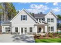 Beautiful home with light siding, stone accents, a covered entry, and a well-manicured lawn at 7128 Trappers Ct, Zebulon, NC 27597
